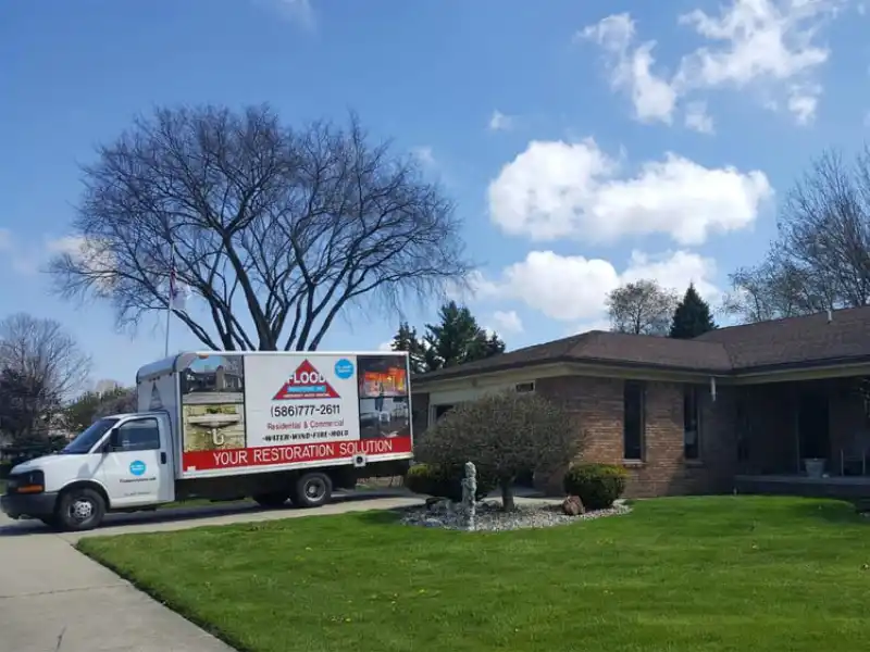 Flood and Fire company truck parked in a residential driveway. water damage restoration services
